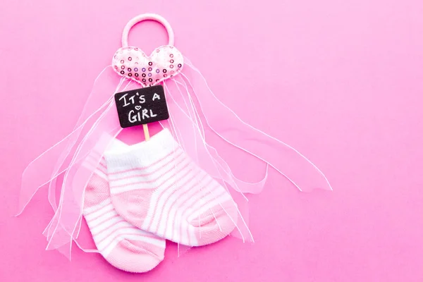 Baby Girl - pink and white socks with heart on pink background with It's a Girl blackboard sign