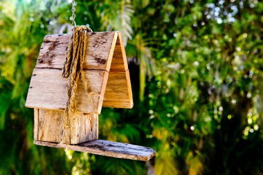 Yeşillik backgrou karşı asılı basit rustik ahşap kuş yuvası