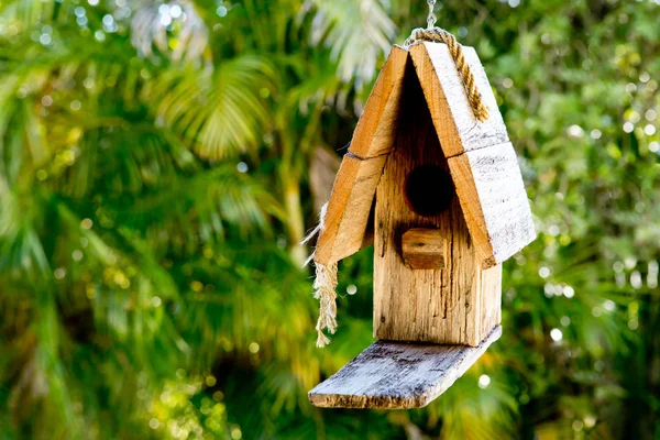 Jednoduchý rustikální dřevěný holubník visí proti zelení poz — Stock fotografie