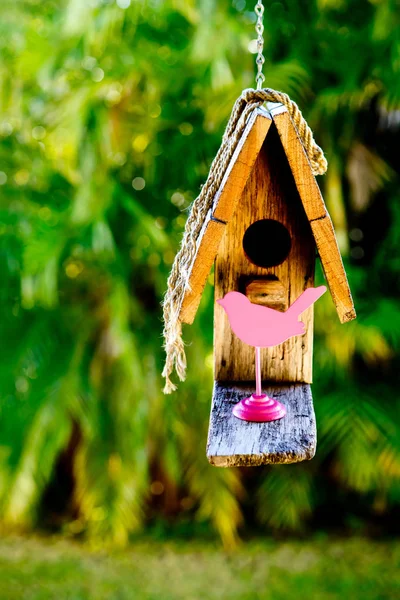 Jednoduchý rustikální dřevěný holubník visí proti zelení poz — Stock fotografie