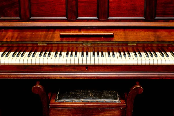 Antyczne pianino - widok z przodu klawiszy fortepianu i stołek — Zdjęcie stockowe