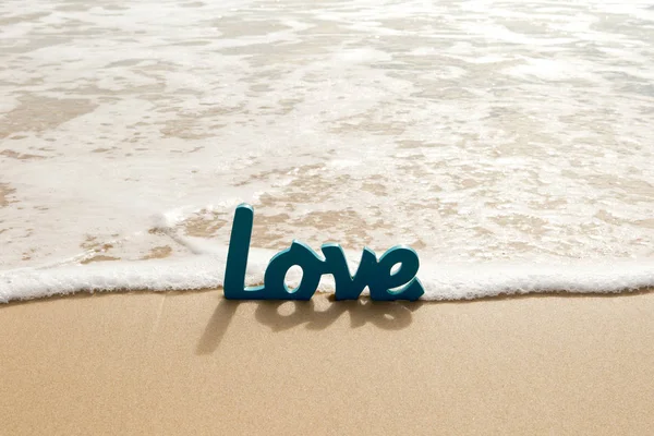 Blue Wooden Love palavra na areia com ondas na praia — Fotografia de Stock