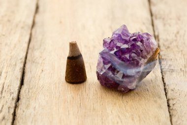 Burning incense cone with amethyst crystal with wafting smoke on clipart
