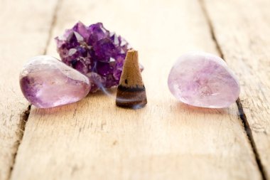 Burning incense cone with amethyst crystals with wafting smoke o clipart