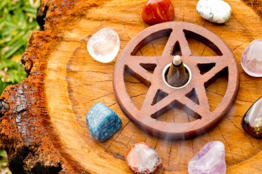 Burning incense cone  in wooden pentacle incense holder on natur clipart