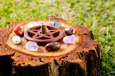 Burning incense cone  in wooden pentacle incense holder on natur clipart