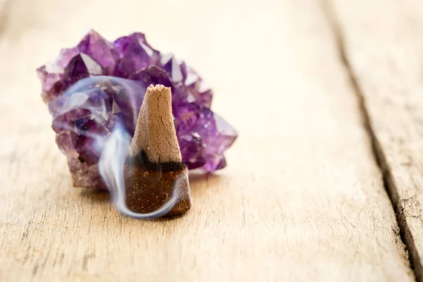 Cono de incienso ardiente con cristal de amatista con humo flotante en —  Fotos de Stock