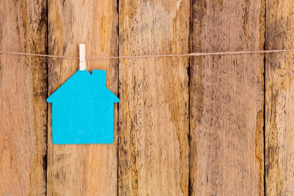 Modrá barva dřevěný dům tvar visí na provázku proti rustikální w — Stock fotografie