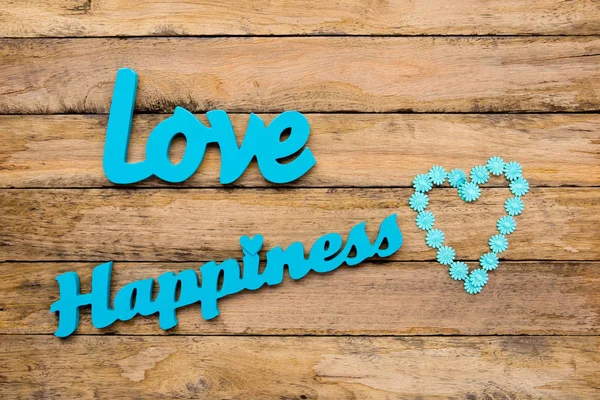 Liefde en geluk - blauw, turquoise houten woorden met hart shap — Stockfoto