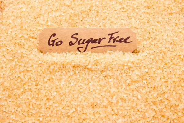 Go Sugar Free - handwritten on label sitting in raw sugar granul
