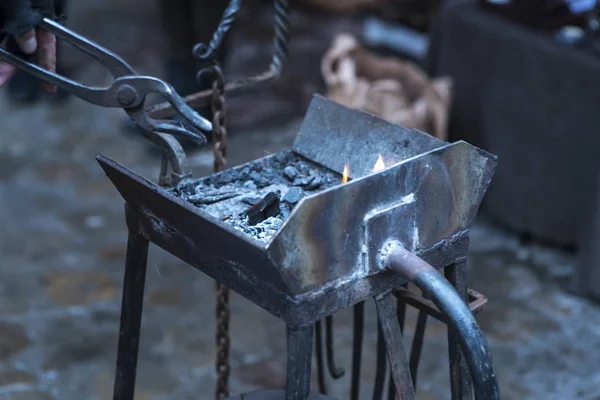 A metal fabricator utilizing a torch to heat up a piece of metal in order to shape it utilizing a forging technique developed over hundred years ago. — Stock Photo, Image