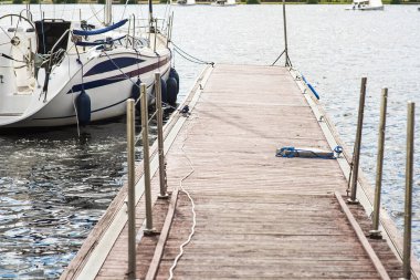 Etrafına demirleme halatı bağlanmış bir demirleme halatı arka planda tekne ve gemilerle limandaki bir demirleme limanında ve teknelerde.