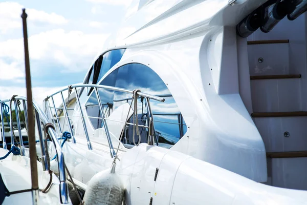 Nautical background of a row of luxury yachts, with black tinted windows and chrome metal railings on white fiber glass bows — Stock Photo, Image