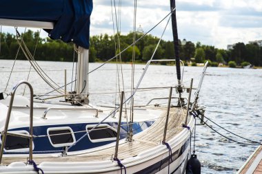 Etrafına demirleme halatı bağlanmış bir demirleme halatı arka planda tekne ve gemilerle limandaki bir demirleme limanında ve teknelerde.