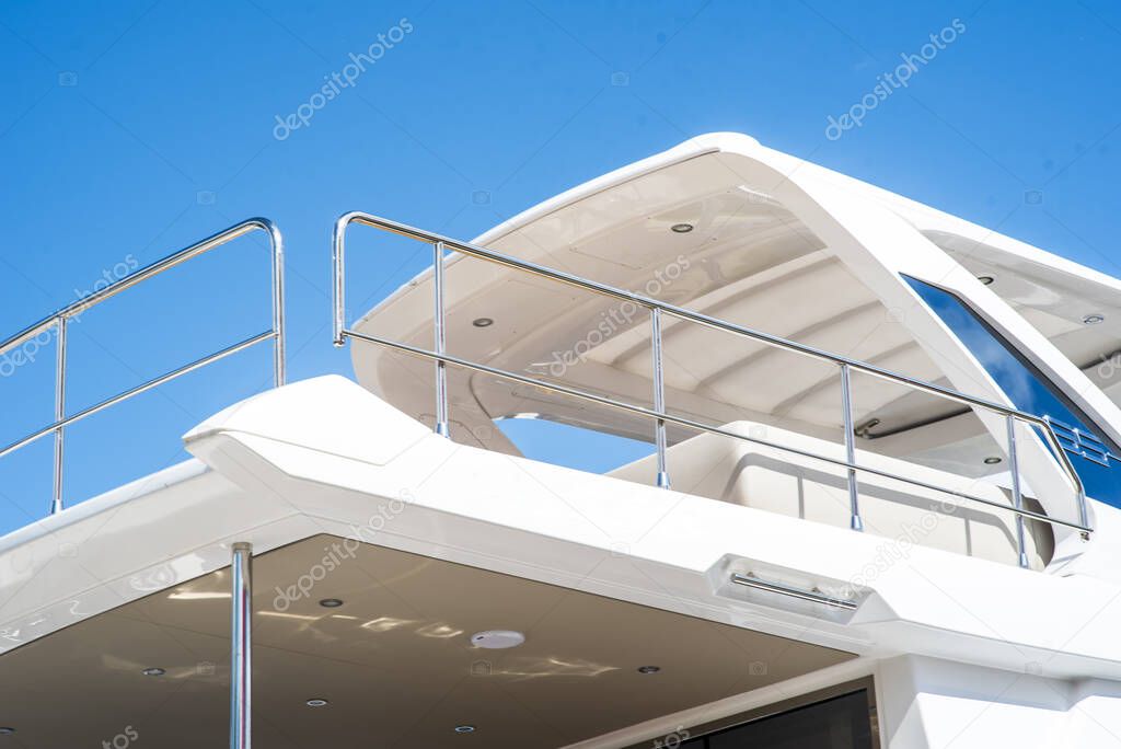Nautical background of luxury yachts, with black tinted windows and chrome metal railings on white fiber glass bows