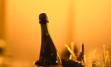 Sıcak bir ışıkta bir şişe şampanya..