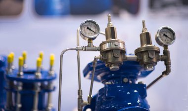 Basınç göstergesi psi metre boru ve su sistemi vanaları endüstriyel odak sol yakın plan beyaz ışık bulanık arka plan.