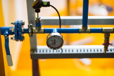 Basınç göstergesi psi metre boru ve su sistemi vanaları endüstriyel odak sol yakın plan beyaz ışık bulanık arka plan