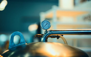 Basınç göstergesi psi metre boru ve su sistemi vanaları endüstriyel odak sol yakın plan beyaz ışık bulanık arka plan.