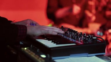 Bir müzisyen synthesizer çalış ve davulcu ritim izler