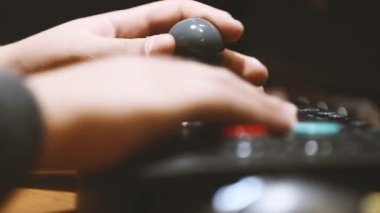 Antika video oyunları oynamak için atari salonunun renkli tuşuna basan çocuk