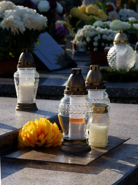 burning candle on tomb in cemetery