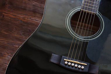 Ahşap arka plan üzerinde siyah akustik gitar