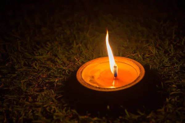 Closeup of candle light on grass floor — Stock Photo, Image