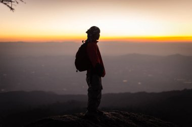 Gün batımı manzarasına bakan hafif siluet insan