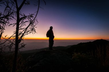 Gün batımı manzarasına bakan hafif siluet insan