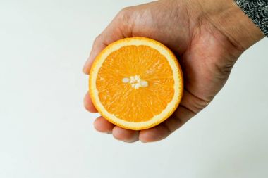 Organik portakal üzerinde elini tutarak dilim