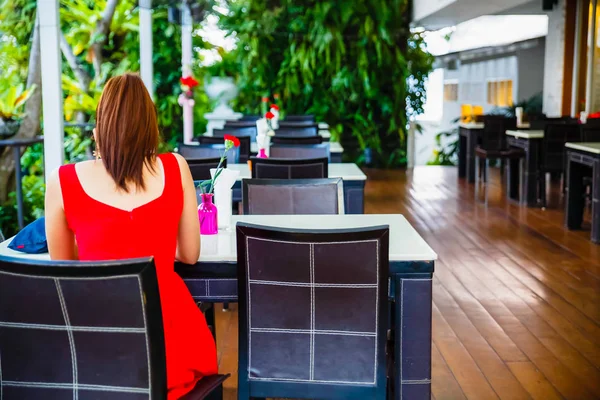 Restaurang atmosfär, träbord med vit topp och röda nejlikan — Stockfoto