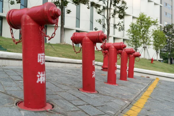 Un groupe de bouches d'incendie rouges à côté du bâtiment — Photo