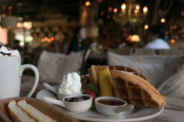 A plate of waffle with banana and strawberry, whipping cream, blueberry and syrup, delicious, yummy — Stock Photo, Image