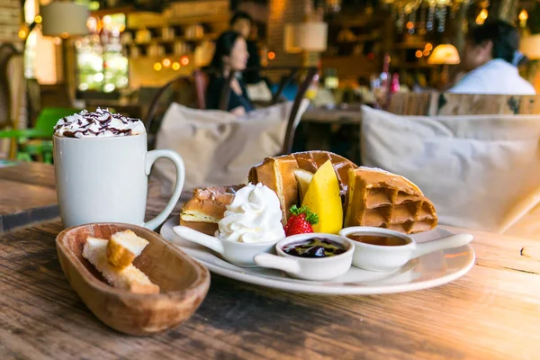 A plate of waffle with banana and strawberry, whipping cream, blueberry and syrup, delicious, yummy — Stock Photo, Image