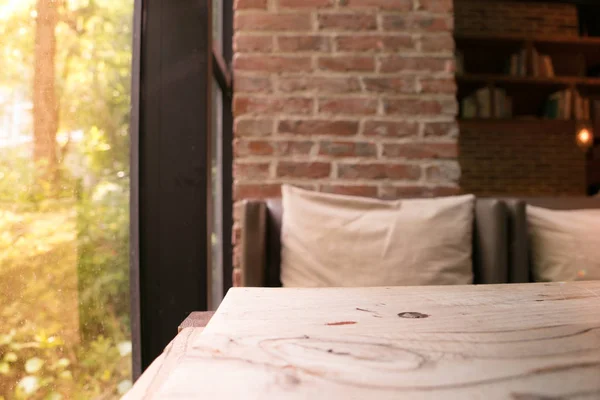 De träbord och suddig soffa bredvid ett fönster av coffee shop — Stockfoto