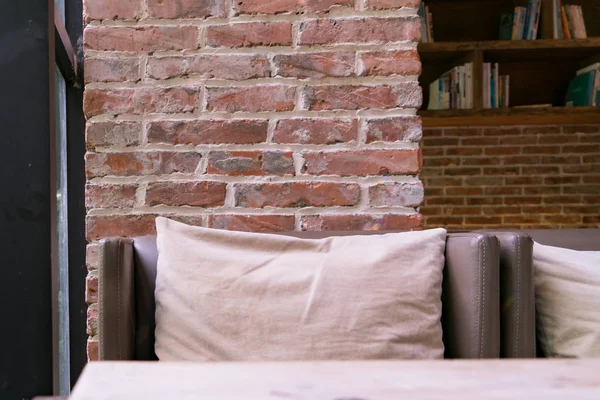 Skórzana kanapa i Poduszka z czerwonej cegły tło w kawiarni — Zdjęcie stockowe