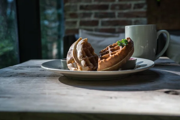 2 pieces of waffle with a white cup of coffee on the wooden table — Stock Photo, Image
