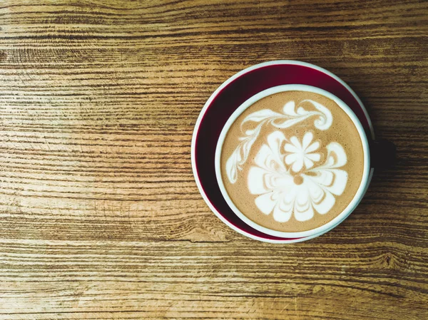 Café mocha quente ou capuchino no copo verde com padrão de luxo na mesa de madeira — Fotografia de Stock