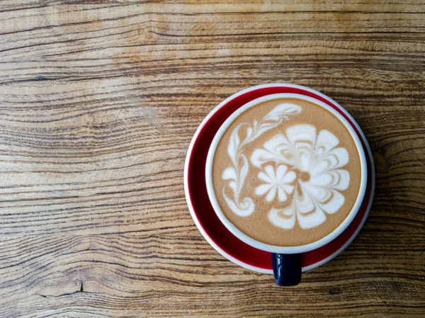 Caffè caldo moka o capuchino nella tazza verde con motivo di lusso sul tavolo di legno — Foto Stock