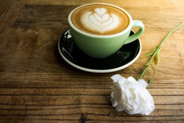 Sıcak mocha kahve ya da capuchino kalp desen ve ahşap masa üzerinde beyaz Karanfil çiçek