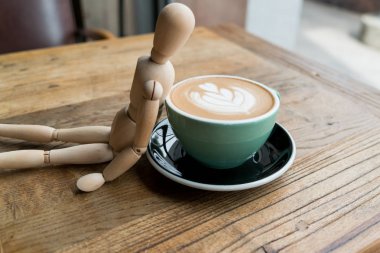 Sıcak mocha kahve veya capuchino yeşil Kupası tahta masada ahşap adam tarafından yalın