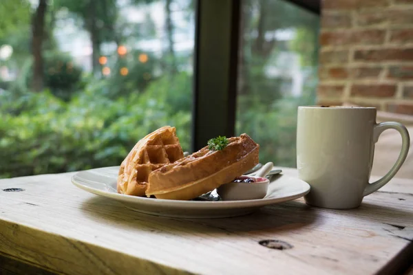 2 Waffelstücke mit einer weißen Tasse Kaffee auf dem Holztisch — Stockfoto