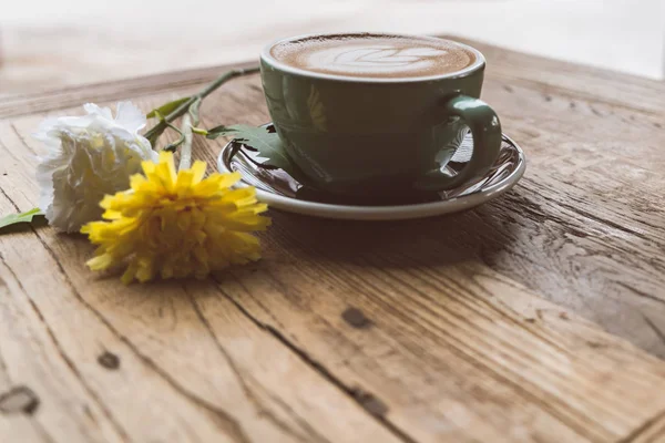 핫 모카 커피 또는 capuchino 나무 테이블에 심장 패턴 및 노란색 꽃 — 스톡 사진