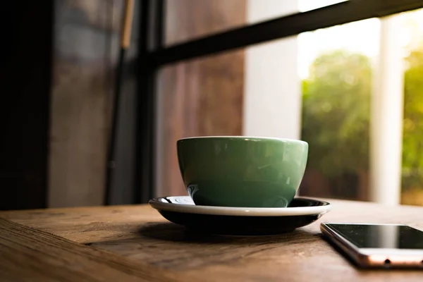 나무 테이블에 스마트 폰으로 커피 한잔 — 스톡 사진