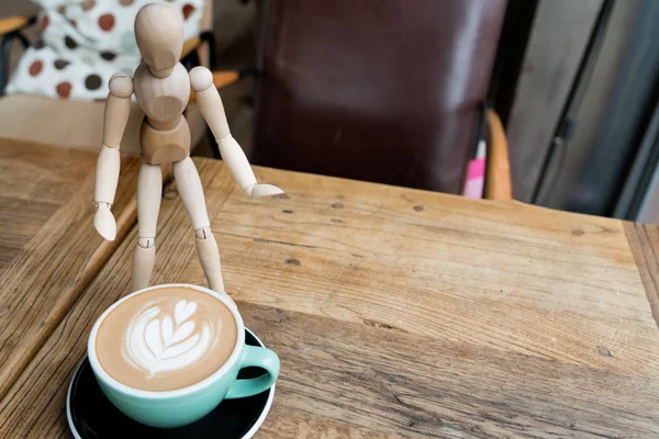 木製のテーブルの上に立っている木製の男とグリーンカップでホットモカコーヒーやカプチーノ — ストック写真