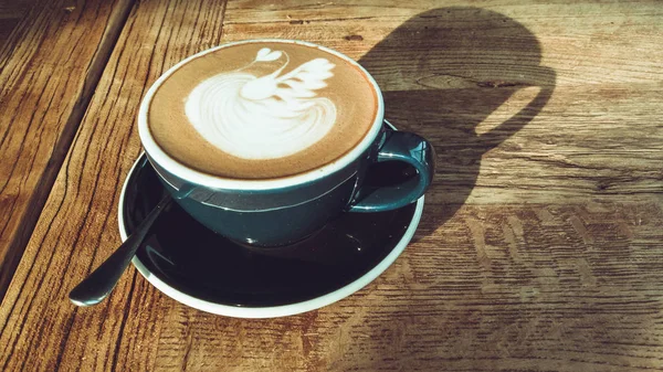 Café mocha quente ou cappuccino no copo azul com padrão de luxo na mesa de madeira — Fotografia de Stock