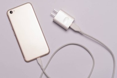 Beyaz akıllı telefon, şarj kablosu ile izole