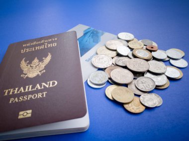 Uluslararası para ve mavi arka plan üzerinde tasarruf hesap cüzdanı ile Tayland pasaportu