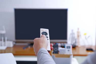 bir kadın elini tut siyah ekran Tv oturma odasında Tv kutusunun uzaktan kumanda